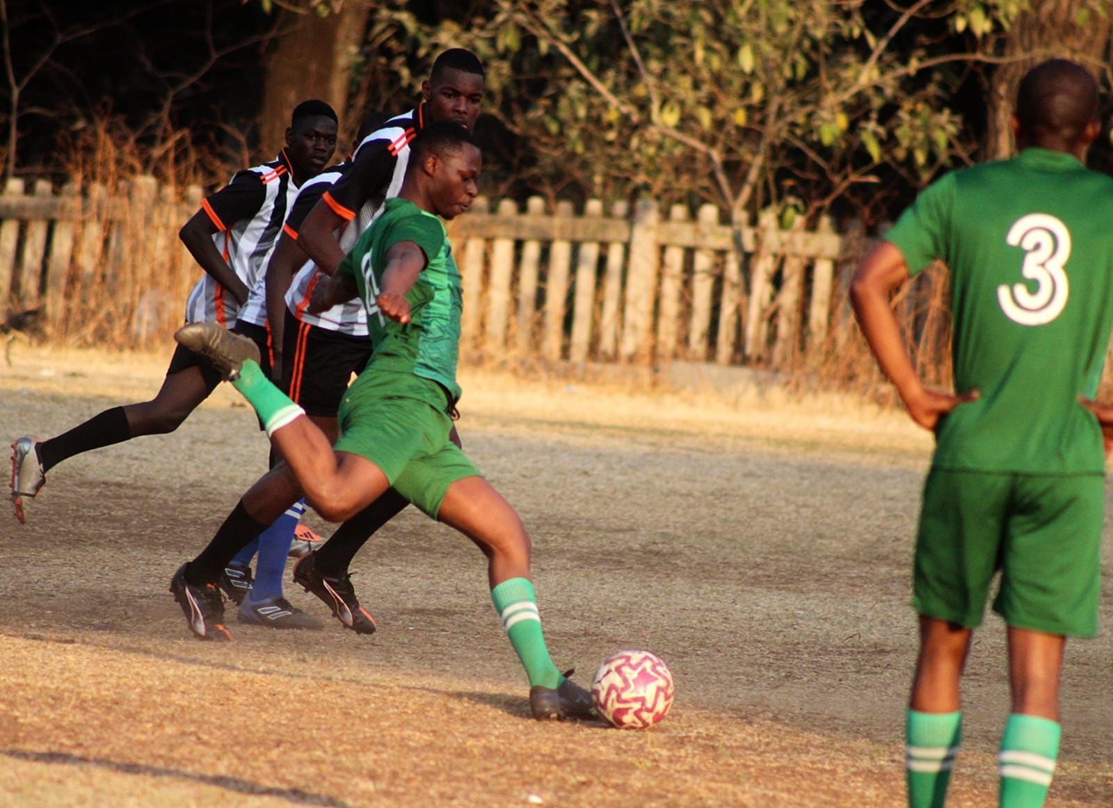 Players chasing the ball in competitive match